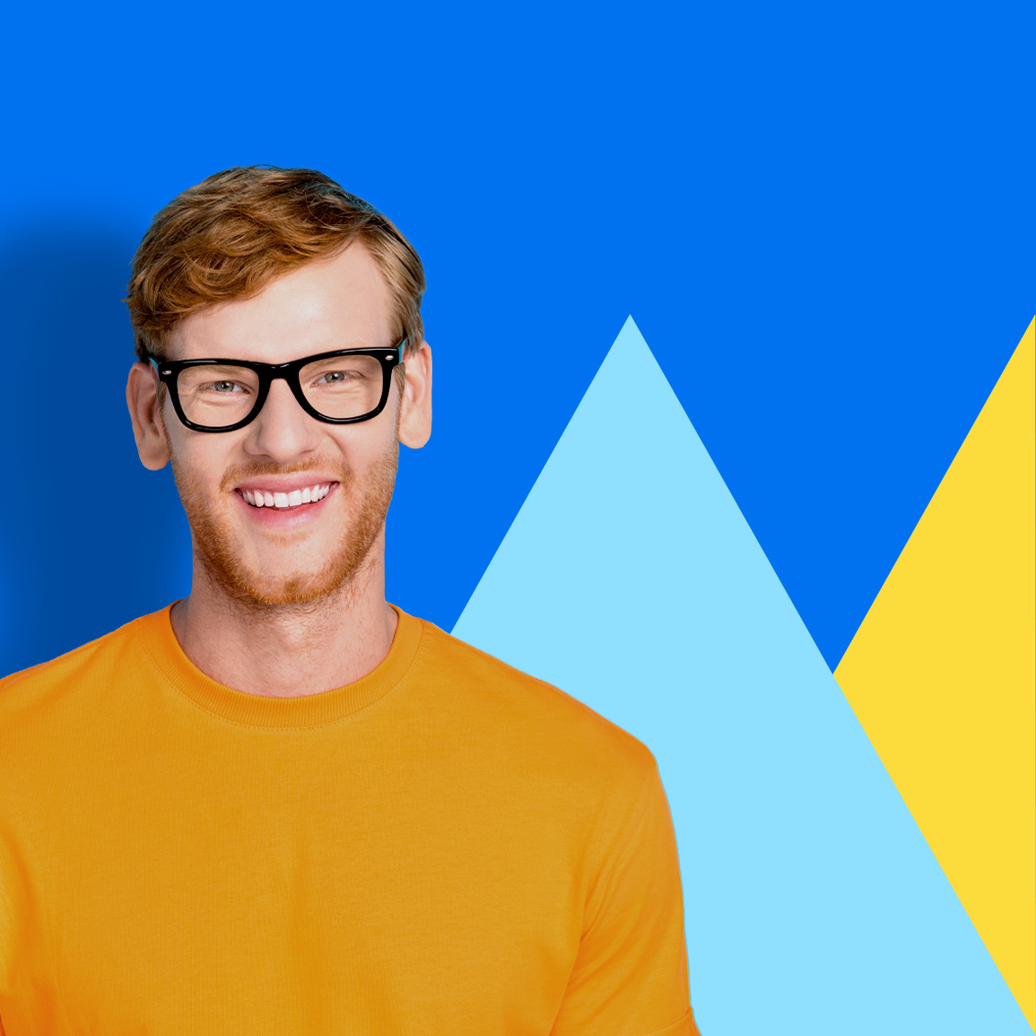 Man with glasses and a yellow sweater standing in front of a blue background with two triangles (light blue and yellow).