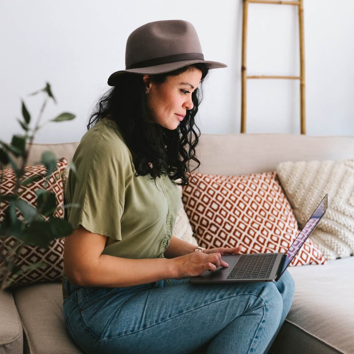 Woman in hat looking at laptop